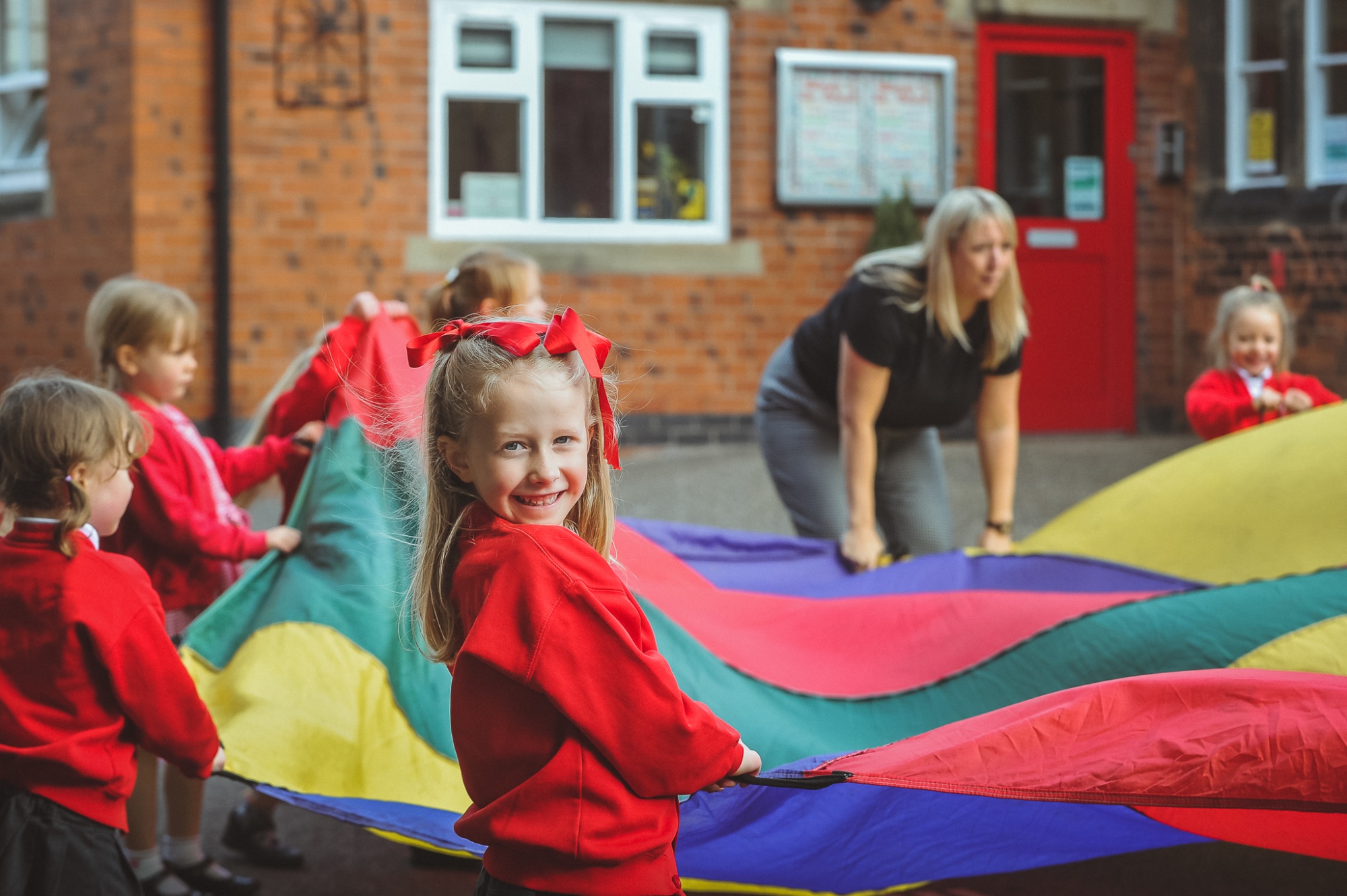 Students in the playground with outdoor parachute